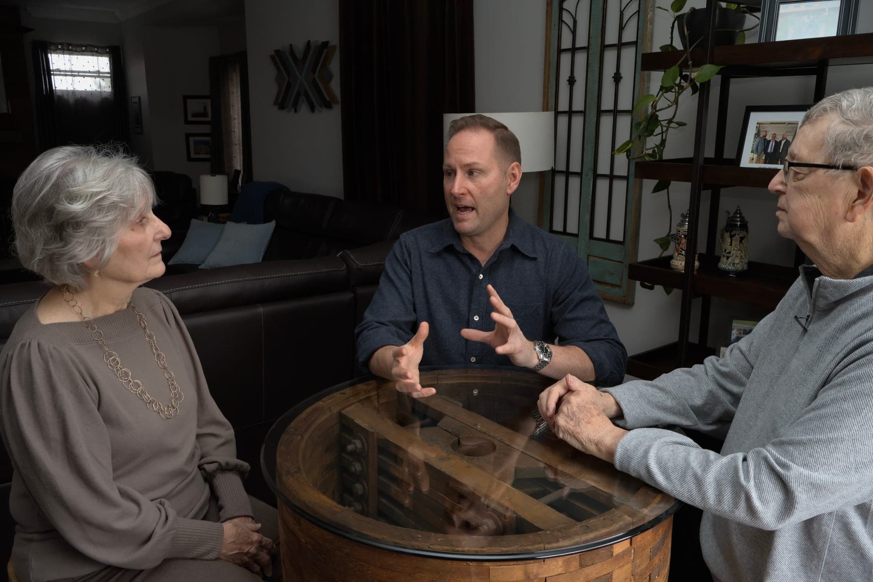 Thomas West talking with two older residents around a table